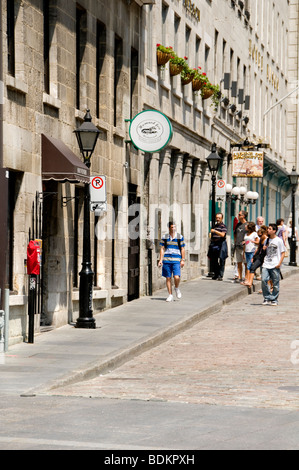 I turisti a piedi attraverso una strada a ciottoli nel vecchio quartiere di Montreal, Quebec, Canada Foto Stock