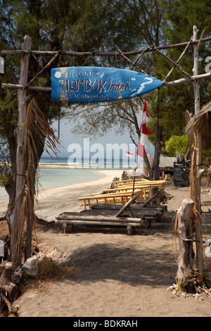 Indonesia, Lombok, Gili Air, Lombok Indah lungomare bar e bungalows segno dipinto sulla vecchia tavola da surf Foto Stock