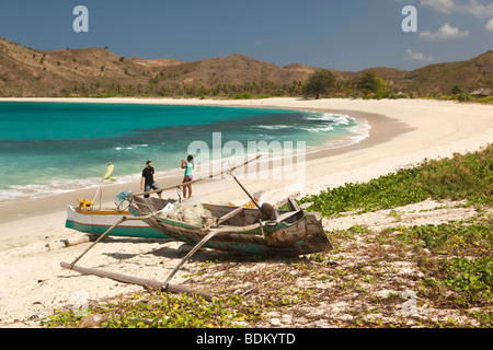 Indonesia, Lombok, South Coast, Mawun, spiaggia, i visitatori di prendere foto ricordo tra colorfully dipinto barche da pesca Foto Stock