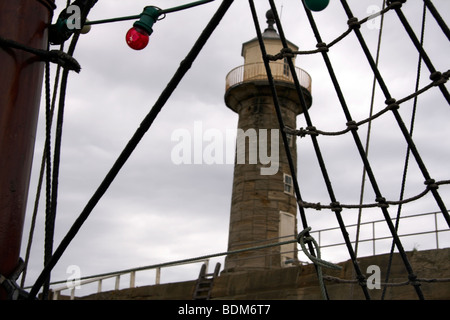 Tall Ship rigging, passato a vela Molo Ovest Lighthouse, Whitby Harbour, North Yorkshire, Inghilterra, Regno Unito Foto Stock