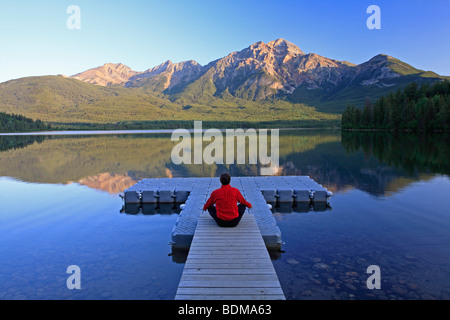 Metà maschio età meditando sul dock a Lago Piramide, il Parco Nazionale di Jasper, Alberta, Canada. Foto Stock