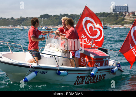 Ice Cream venditori. Giovani uomini di vendita di gelato da una barca off Bournemouth Beach. Il Dorset. Regno Unito. Foto Stock