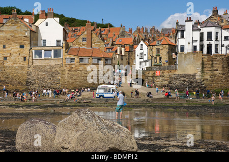 Persone turisti visitatori sulla spiaggia di mare in estate Robin Hods Bay North Yorkshire Inghilterra Regno Unito GB Great La Gran Bretagna Foto Stock