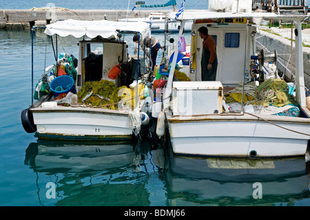 Due locali greco barche da pesca si prepara a vela fuori dal molo a Corfù Docks Foto Stock