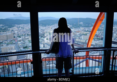 Giovane donna che guarda la vista panoramica della città dalla crepuscle. Piattaforma di Osservazione di Kyoto Tower. Il protocollo di Kyoto. Kansai. Giappone Foto Stock