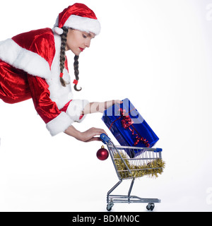 Giovani divertente ed espressivo donna vestiti da Babbo Natale sta facendo il suo shopping Foto Stock