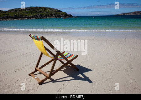 Sedia a sdraio sulla remota spiaggia scozzese deserta e vuota. Il mare di Achmelvich Bay a Lochinver, Sutherland, Scozia, Regno Unito Foto Stock