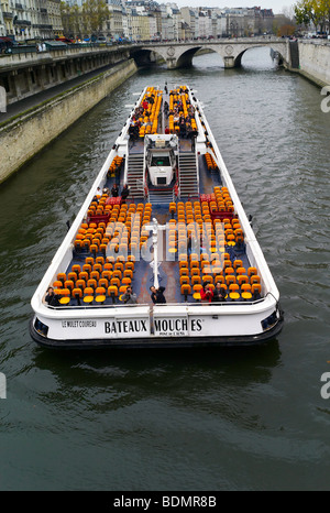 Una barca fluviale sulla Senna a Parigi si avvicina un ponte vicino a Notre Dame. Foto Stock