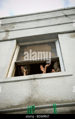 Le mani e le braccia visto uscire fuori da una finestra al piano di sopra di attendere per la cattura di talloni gettato da Mardi Gras galleggianti in New Orleans. Foto Stock