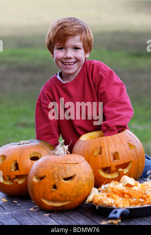 Ragazzo carving un jack-o-lantern da una zucca di Halloween Foto Stock