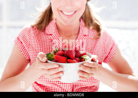 Donna che mantiene una ciotola di fragole Foto Stock