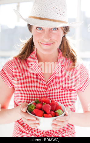 Donna che mantiene una ciotola di fragole Foto Stock