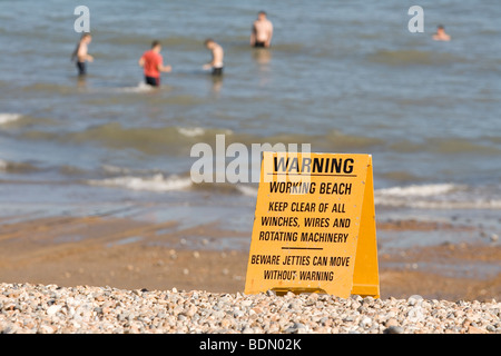 Segnale di avvertimento sulla spiaggia mentre la gente nuotare. Foto Stock