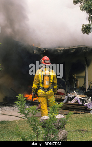 Di spegnere un incendio in auto per fiamma di fumo Pericolo rischio maschera casco serbatoio di ossigeno spray flessibile di mettere fuori lotta Foto Stock