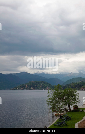 Vista del lago d'Orta su un giorno d'estate con l'Isola di San Giulio a distanza e i bordi di un giardino in primo piano Foto Stock