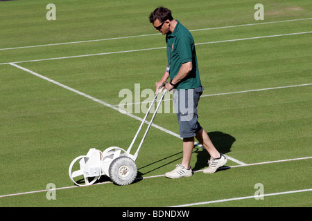 Le linee bianche sono ri-verniciati esternamente tribunali prima del gioco durante il 2009 Wimbledon Tennis Championships Foto Stock