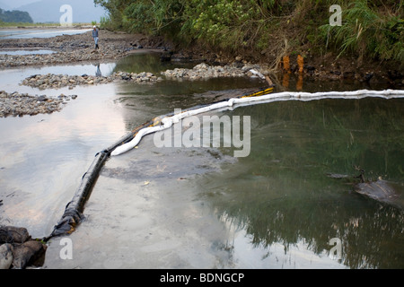 Fuoriuscite di olio in un fiume amazzonico con il braccio in posizione di contenere slick. Foto Stock