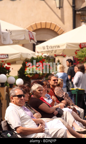 Varsavia Polonia turisti seduta sul banco in piazza della città vecchia tra le caffetterie all'aperto - Stare Miasto Foto Stock