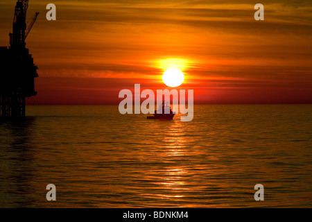 Sun impostata a oriente brae oil rig Foto Stock