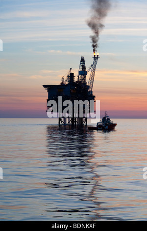 Sun impostata a oriente brae oil rig Foto Stock