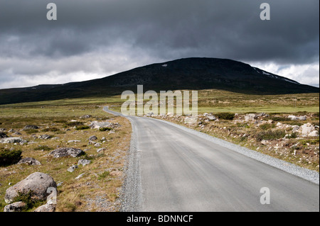 Una tempesta in avvicinamento su una strada solitaria alta tra le montagne sopra Lillehammer, Norvegia Foto Stock