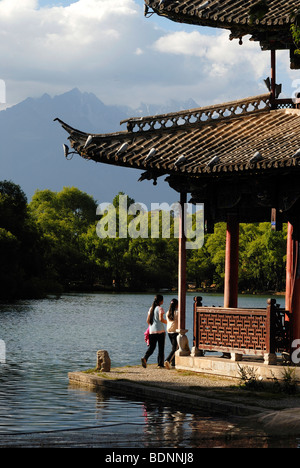 Due le donne cinesi a piedi attorno alla pagoda del Drago Nero, piscina di fronte al Jade Dragon Snow Mountain Foto Stock