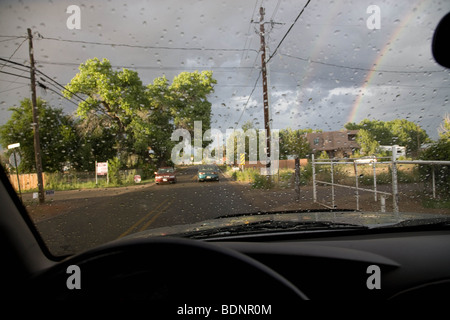 Vista della strada e rainbow attraverso il parabrezza della vettura Foto Stock