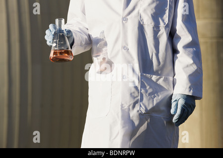 Scienziato tenendo un pallone di campione di acqua Foto Stock