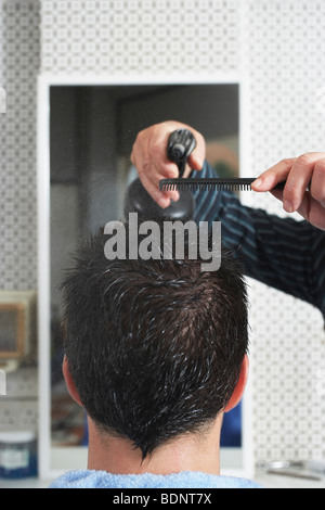 Barbiere spruzzatura mans capelli in un barbiere, close-up Foto Stock