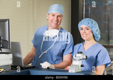 Due chirurghi che lavora su una macchina laser Foto Stock
