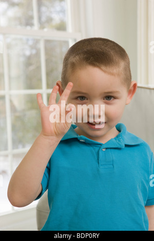 Ragazzo firma la lettera 'F' in American Sign Language Foto Stock