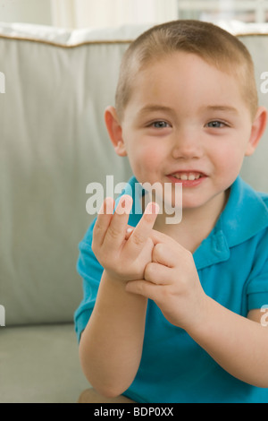 Ragazzo firma la lettera 'W' in American Sign Language Foto Stock