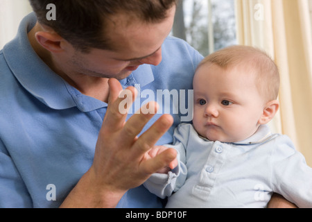 L'uomo firma la parola 'Mommy' in American Sign Language durante la comunicazione con il suo figlio