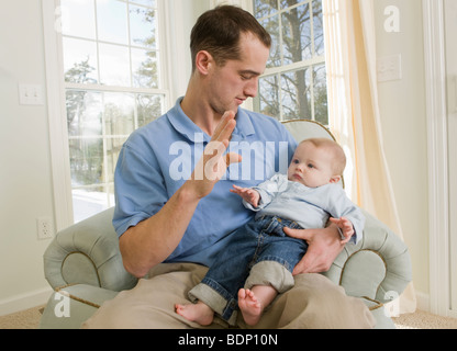 L'uomo firma la parola 'B' in American Sign Language durante la comunicazione con il suo figlio