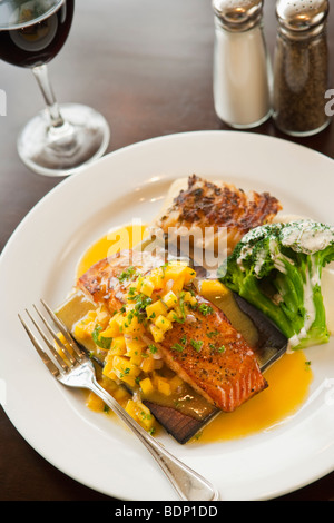 In legno di cedro cuocere il salmone con salsa di mango, broccoli, patate e un bicchiere di pinot nero vino, Ristorante Jane, Santa Barbara Foto Stock