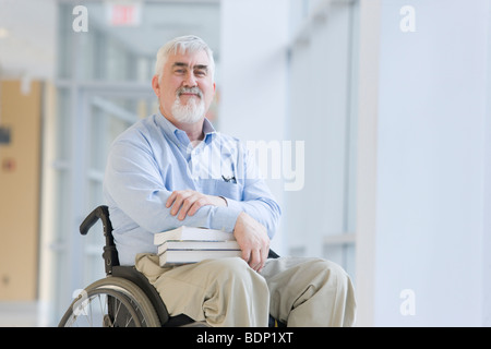 Ritratto di un professore seduto in una sedia a rotelle Foto Stock