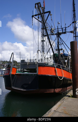 Orange peschereccio legato su una banchina in Yaquina Bay, Newport, Oregon Coast Foto Stock