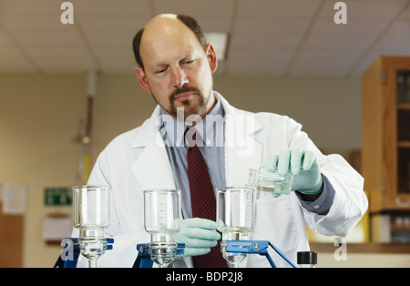 Scienziato il filtraggio di un campione Foto Stock