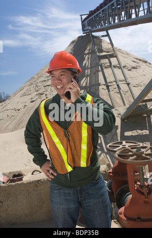 Ingegnere a parlare su un telefono mobile a valvole di controllo Foto Stock