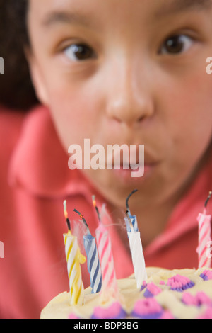 Ragazza soffiando fuori candele su una torta di compleanno Foto Stock