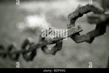 Un vecchio arrugginito legata a catena recinzione Foto Stock