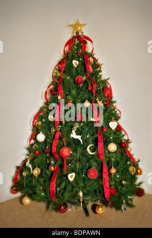 Tradizionale albero di Natale decorato in rosso e tema oro Foto Stock