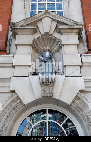 Statua di donna Blue Coat alunno sulla parte esterna di Sir John Cass la fondazione della Scuola Primaria in Aldgate, Londra, Inghilterra, Regno Unito. Foto Stock