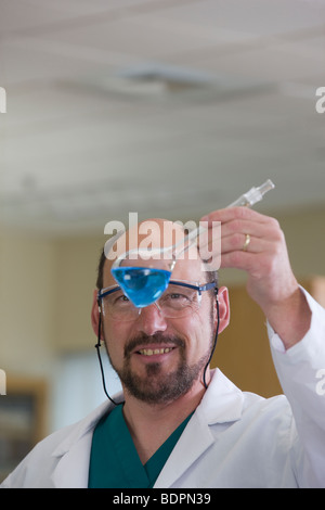 Scienziato esame chimica in un pallone Foto Stock