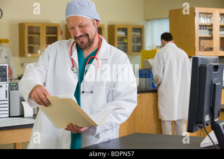 Scienziato esaminando un record Foto Stock