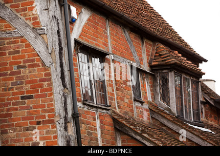 Inghilterra, Berkshire, Cookham, School Lane, legno incorniciata cottage in mattoni con materiale di riempimento o infill appoggiata al angolo allarmante Foto Stock