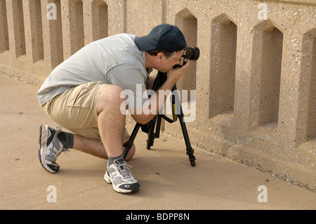 Fotografo professionista acquisisce un interessante oggetto attraverso un ponte ferroviario. Foto di Darrell giovani. Foto Stock