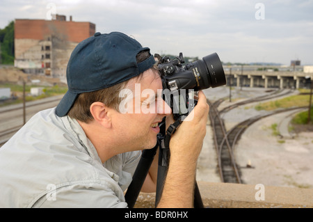 Fotografo professionista acquisisce un interessante argomento da un ponte. Foto di Darrell giovani. Foto Stock