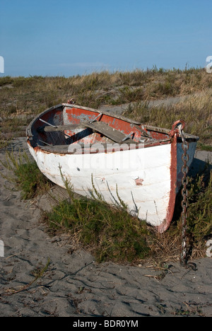 Abbandonato il vecchio double ended arrugginimento riga barca spiaggiata su una duna erbosa in Fort Worden stato parco vicino a Port Townsend Washington Foto Stock