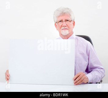 Imprenditore senior tenendo un cartello bianco su bianco Foto Stock